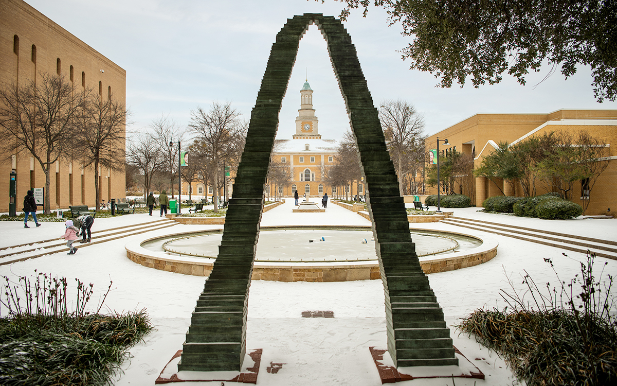 Snow covers the UNT Library Mall and fountain